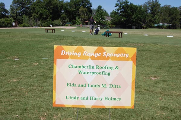 Driving range sponsor sign staked beside a practice range